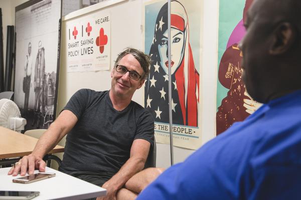 Pearl Jams Stone Gossard is interviewed by Real Change vendor Darrell Wrenn right Photo by Matthew S Browning