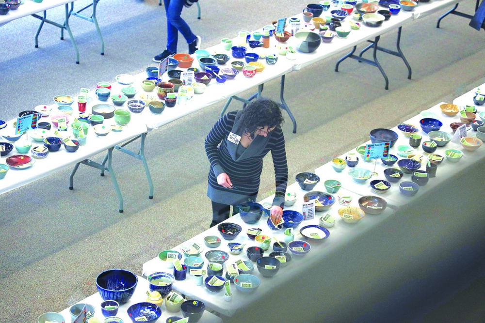 Pierce County potter Jen Davis checks one of her bowls. She has contributed for 15 years.